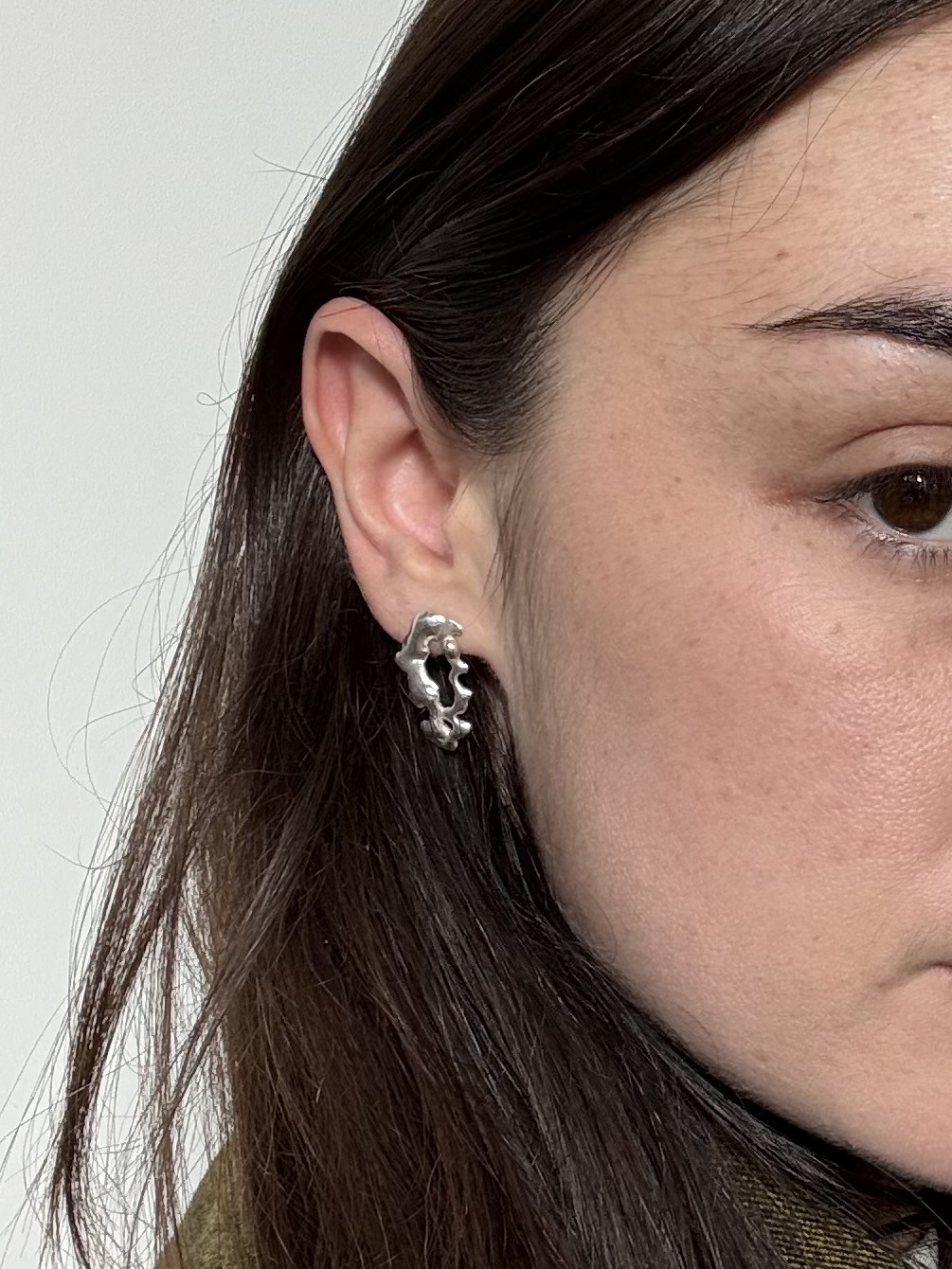 Une photo de la boucle d'oreille ERROR 404 portée sur une modèle aux cheveux bruns et peau pâle